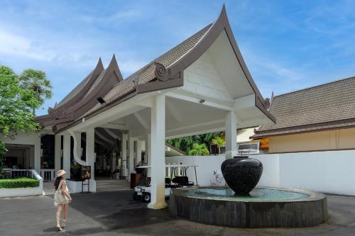 a woman standing in front of a building at Centara Kata Resort Phuket in Kata Beach