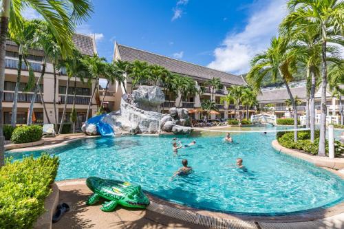 a pool at a resort with people swimming in it at Centara Kata Resort Phuket in Kata Beach