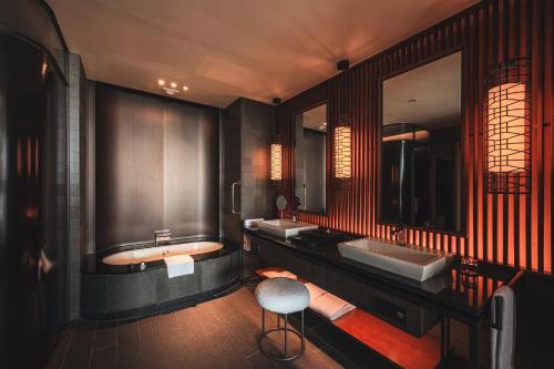 a bathroom with two sinks and a tub and a stool at Ananti at Busan Cove in Busan