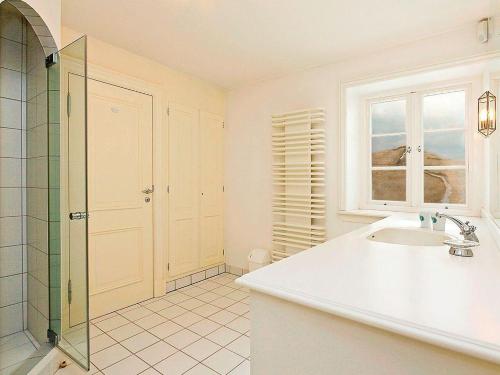a white bathroom with a sink and a shower at Heidehaus in Kampen