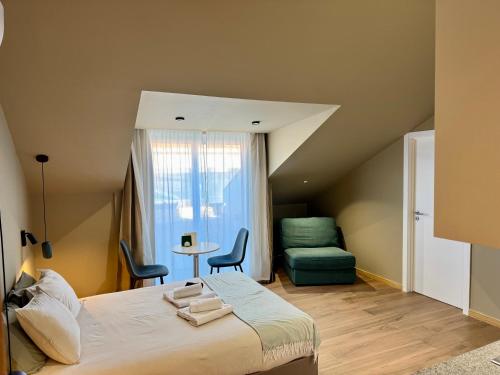 a bedroom with a bed with two chairs and a couch at Lovely studio fully equipped near subway N10 - Shared bathroom with another Studio in Lisbon
