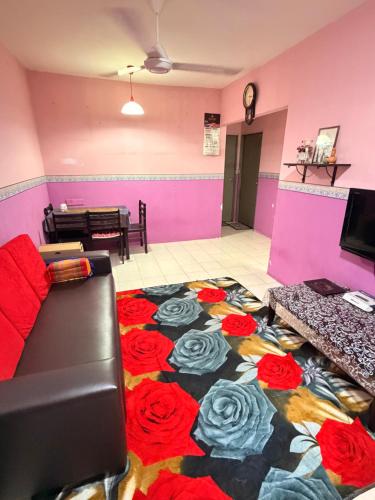 a living room with a carpet with roses on the floor at Homestay Arich in Permatang Pauh