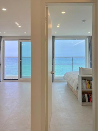 a bedroom with a bed and a view of the ocean at Mr. Slow in Sokcho