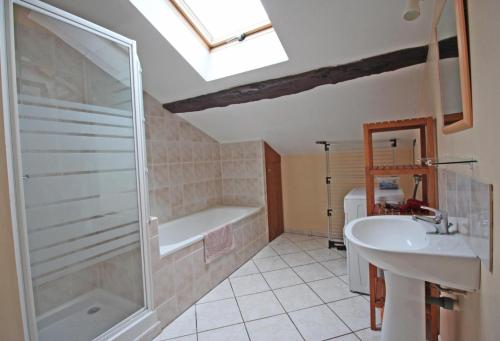 a bathroom with a shower and a sink and a tub at Le bourg in Vaulry
