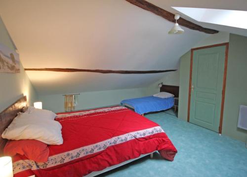 a bedroom with a red bed and blue carpet at Le bourg in Vaulry