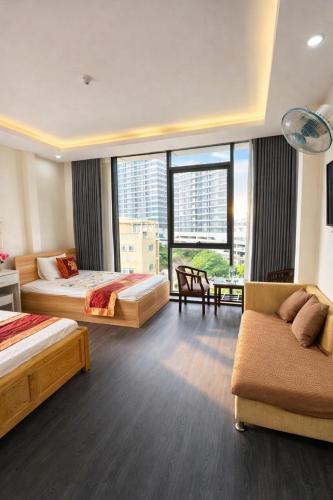 a hotel room with two beds and a couch at Harmony Hotel in Hanoi
