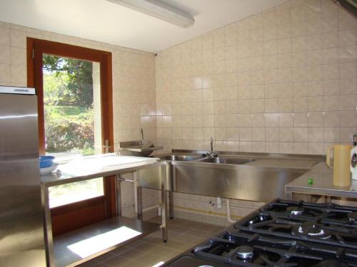 a kitchen with a sink and a stove at La vauloube in Châteauponsac