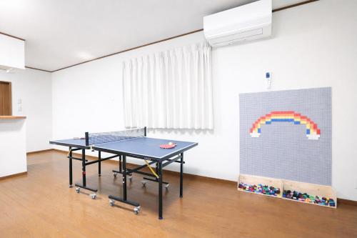 a ping pong table in a room with a rainbow mural at NEW OPEN 庭音日和 一棟貸し 八幡堀徒歩9分 壺湯2つ 近江牛名店至近 子連れ歓迎 水回り2箇所 p2台 in Omihachiman