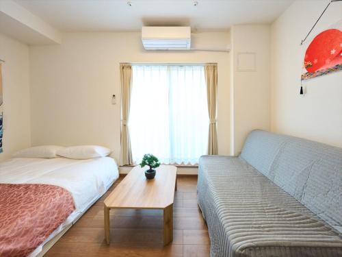 a living room with a bed and a couch at K-Stay TOKYO HANEDA in Tokyo