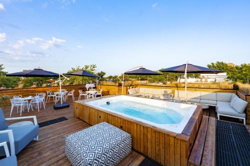 a hot tub on a deck with chairs and umbrellas at Lofts Le Plateau in Montreal