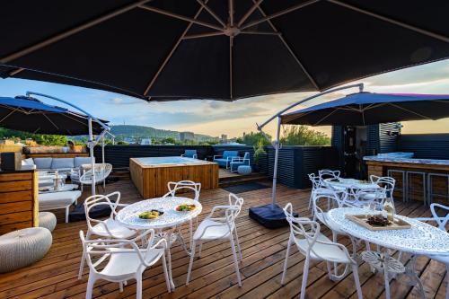 a deck with tables and chairs and umbrellas at Lofts Le Plateau in Montreal