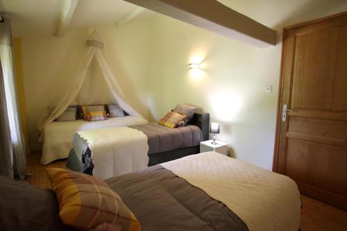 a bedroom with three beds in a room at Le borland in Nantiat