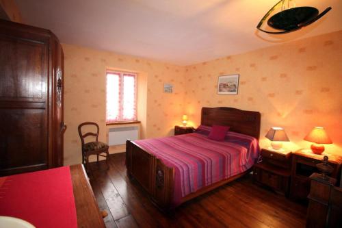 a bedroom with a bed and two tables and a chair at Négrignas in Augne