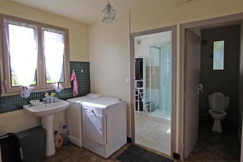 a small bathroom with a sink and a refrigerator at Serre in Augne