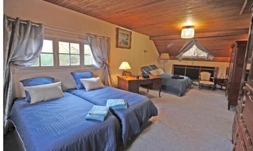 a bedroom with two beds and a desk and a fireplace at Villa du lac in Bujaleuf