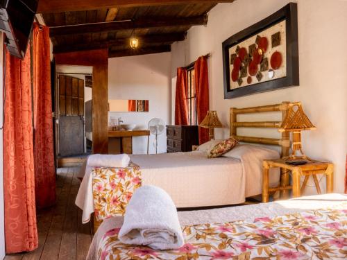 a bedroom with two beds and a table with a lamp at Hotel Hacienda San Bartolo in Xico