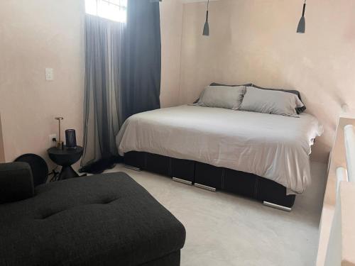 a small bedroom with a bed and a chair at La Belle Dojo in Chelem
