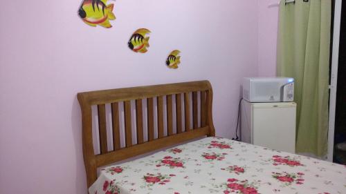Un dormitorio con una cama con flores en la pared. en Suites Canto dos Passaros, en Ilhabela