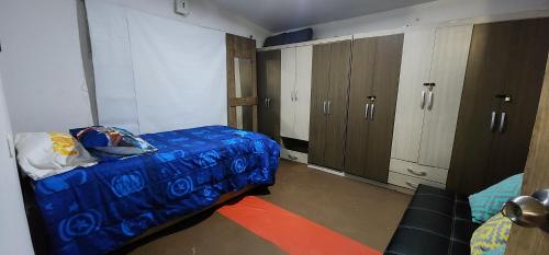 a bedroom with a blue bed and a mirror at Casa de Playa Salgar in Puerto Colombia