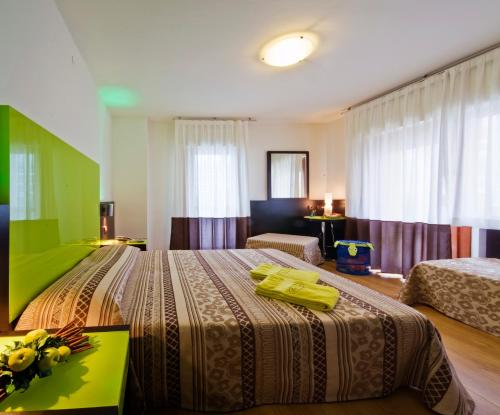 a hotel room with two beds and a table at Hotel Concordia 3S in Bibione