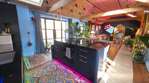 a room with a kitchen with a counter and a living room at Pettifer's Loft in Lincolnshire