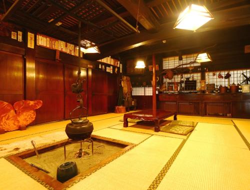 a room with a table and a pot on the floor at Miyamaso in Takayama