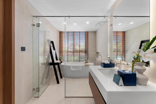 a bathroom with two sinks and a bath tub at Costamigo Phan Thiet, BW Premier Collection in Phan Thiet