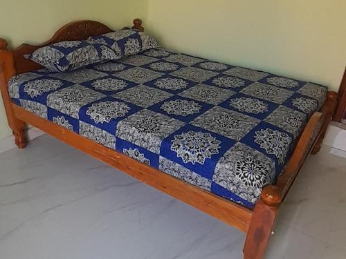 a bed with a blue and white quilt on it at Mahadev Residency templeview in Tiruvannāmalai