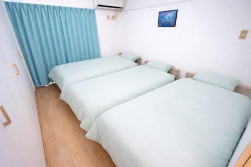two beds in a room with white sheets at マンションルミエールＩ301 rumiereＩ301 in Gifu