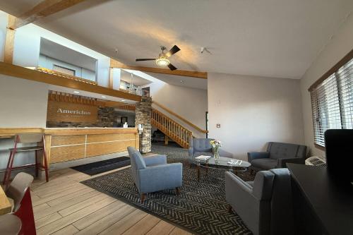 a lobby with couches and chairs and a bar at AmericInn by Wyndham Sioux Falls in Sioux Falls