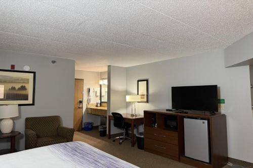 a hotel room with a bed and a flat screen tv at AmericInn by Wyndham Sioux Falls in Sioux Falls