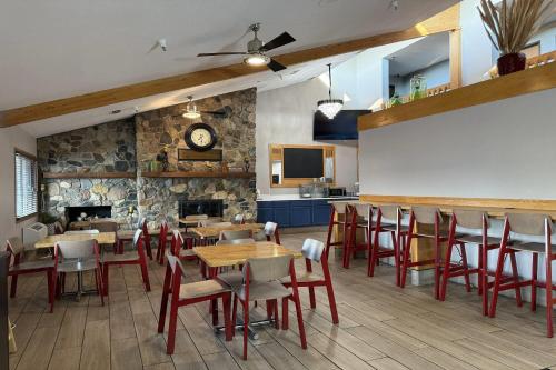 a restaurant with tables and chairs and a stone wall at AmericInn by Wyndham Sioux Falls in Sioux Falls