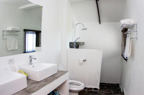 La salle de bains blanche est pourvue d'un lavabo et de toilettes. dans l'établissement Karo Villas, à Koh Tao