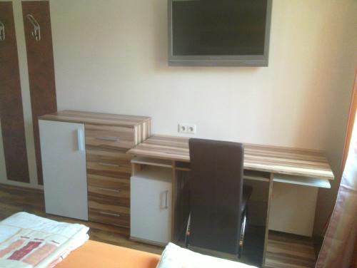 a room with a desk with a television and a chair at Gasthof Paradiesgartl in Kleinpöchlarn