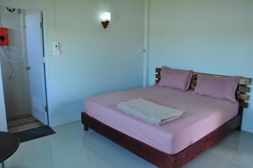 1 cama con almohadas moradas en una habitación en The Rim Riverside Guest House en Nong Khai