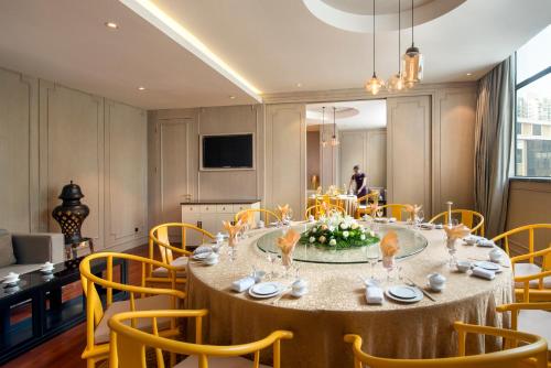 a large dining room with a table and chairs at Sofitel Zhengzhou International in Zhengzhou