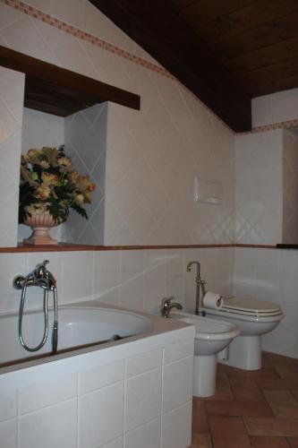 a bathroom with two sinks and a tub and a toilet at La Piazzetta in Bettona