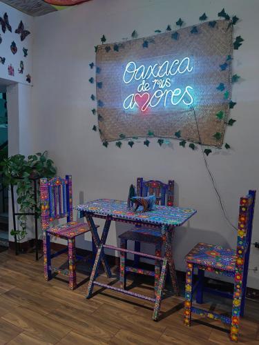 a table with chairs and a sign that saysaca do this authors at Casa los Arcos Oaxaca in Oaxaca City