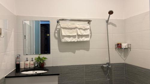 a white bathroom with a sink and a shower at KHÁCH SẠN ROMO in Quảng Ngãi