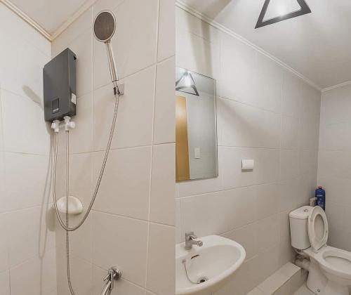 a bathroom with a shower and a toilet and a sink at 8 Spatial Condo in Davao City