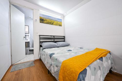 a bedroom with a bed with a yellow blanket on it at KH habitaciones in Manzanillo