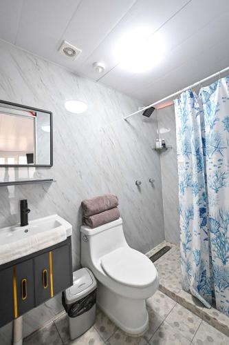 a bathroom with a toilet and a sink and a shower at KH habitaciones in Manzanillo
