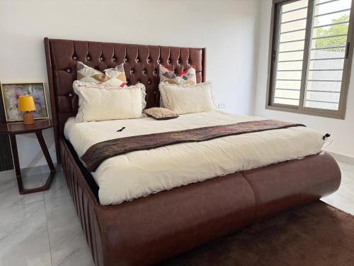 a large bed with a large wooden headboard in a bedroom at Samash villas 2 in Lusaka