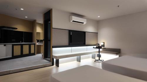 a living room with two beds and a table at Urban Inn, Alor Setar in Alor Setar
