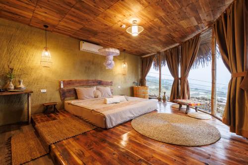 a bedroom with a large bed and a large window at Puluong Qui E Ora in Lũng Tiềm