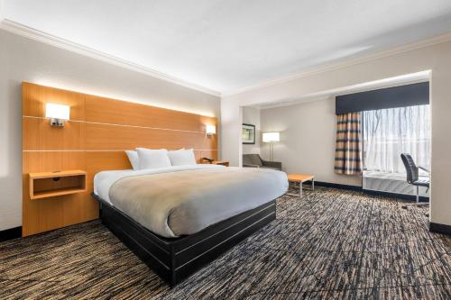 a hotel room with a large bed and a desk at Quality Inn Alexander City in Alexander City