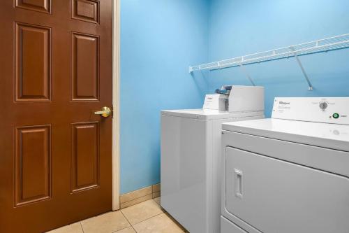 a bathroom with a washing machine and a brown door at Quality Inn Alexander City in Alexander City