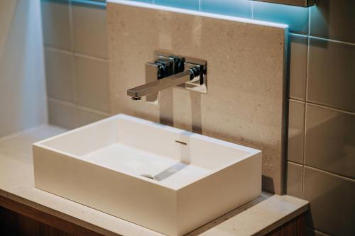 a white sink in a bathroom with aaucet at Clarion Hotel Townsville in Townsville