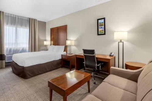 a hotel room with a bed and a desk at Comfort Suites Brenham in Brenham