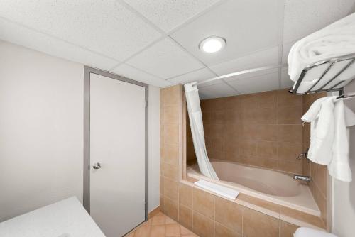 a bathroom with a shower and a bath tub at Suburban Studios, Kearney in Kearney